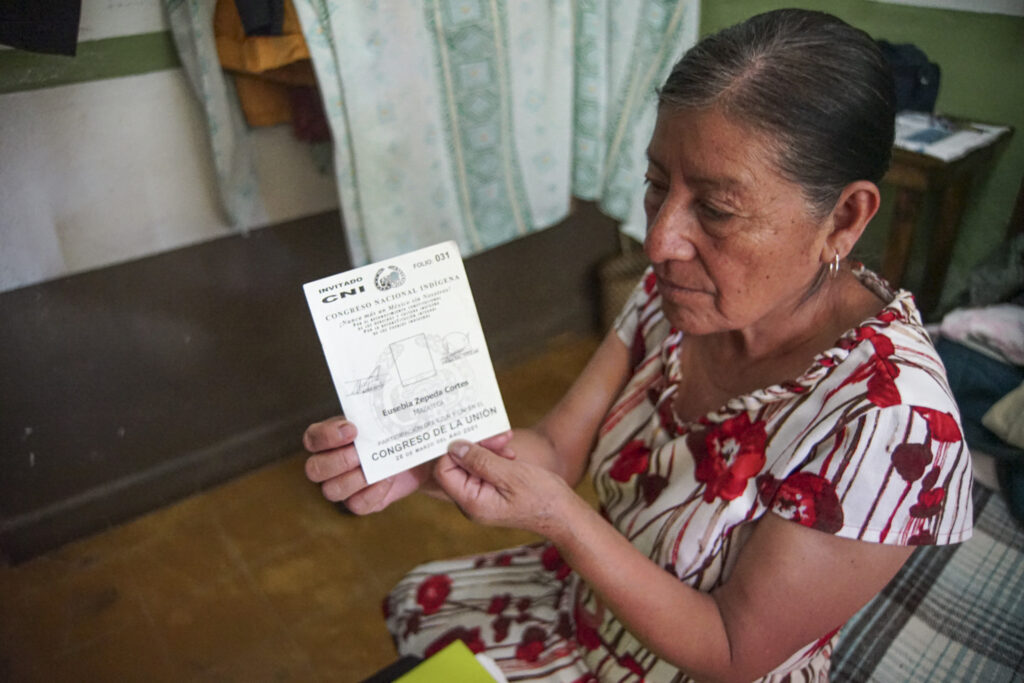 Maestra Eusebia enseñando su credencial de participación en un encuentro del CNI.
